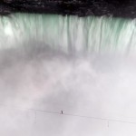 Канатоходец Ник Валленда идет по канату, натянутому над Ниагарским водопадом между США и Канадой. За…