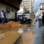 Рабочий пытается отремонтировать трубу в заполненной водой яме в Каракасе, Венесуэла……
