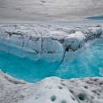Талая вода бежит по траншее, вымытой в поверхности Гренландского ледяного щита, к юго-западу от Илул…